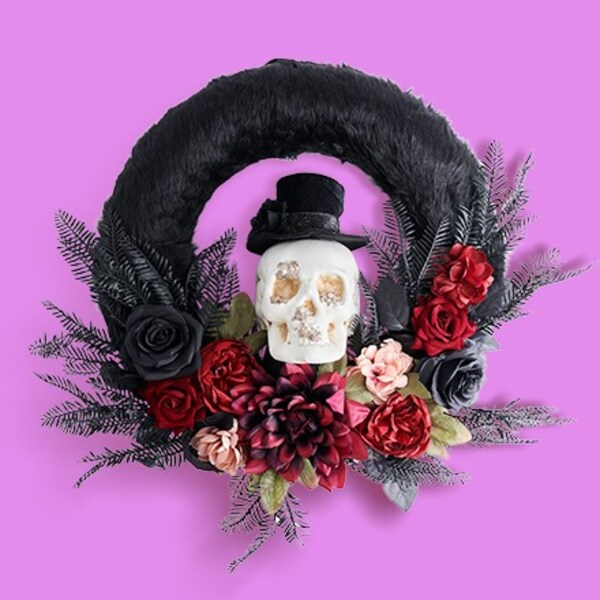 black wreath with white skull and red flowers on purple background